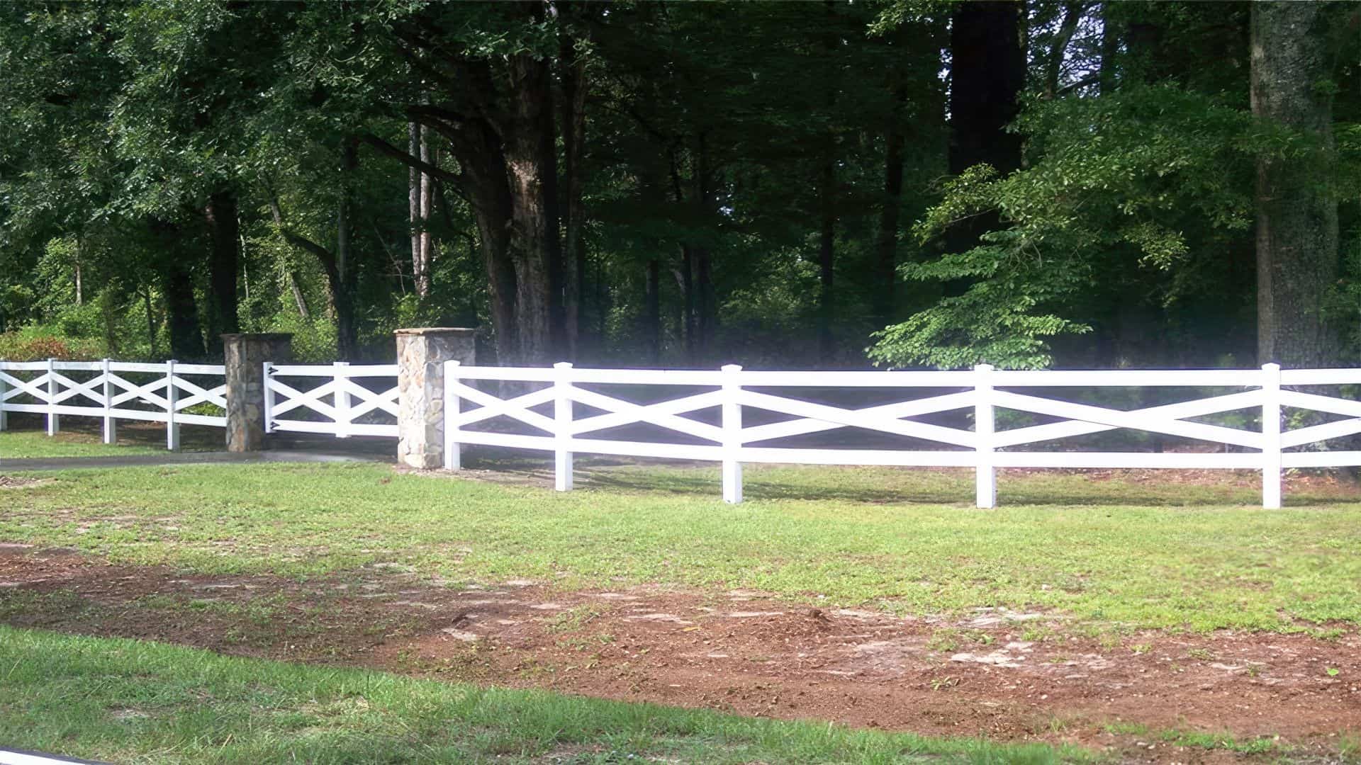Vinyl cross rail ranch style fence as boundary around farm land for an old timely aesthetic.