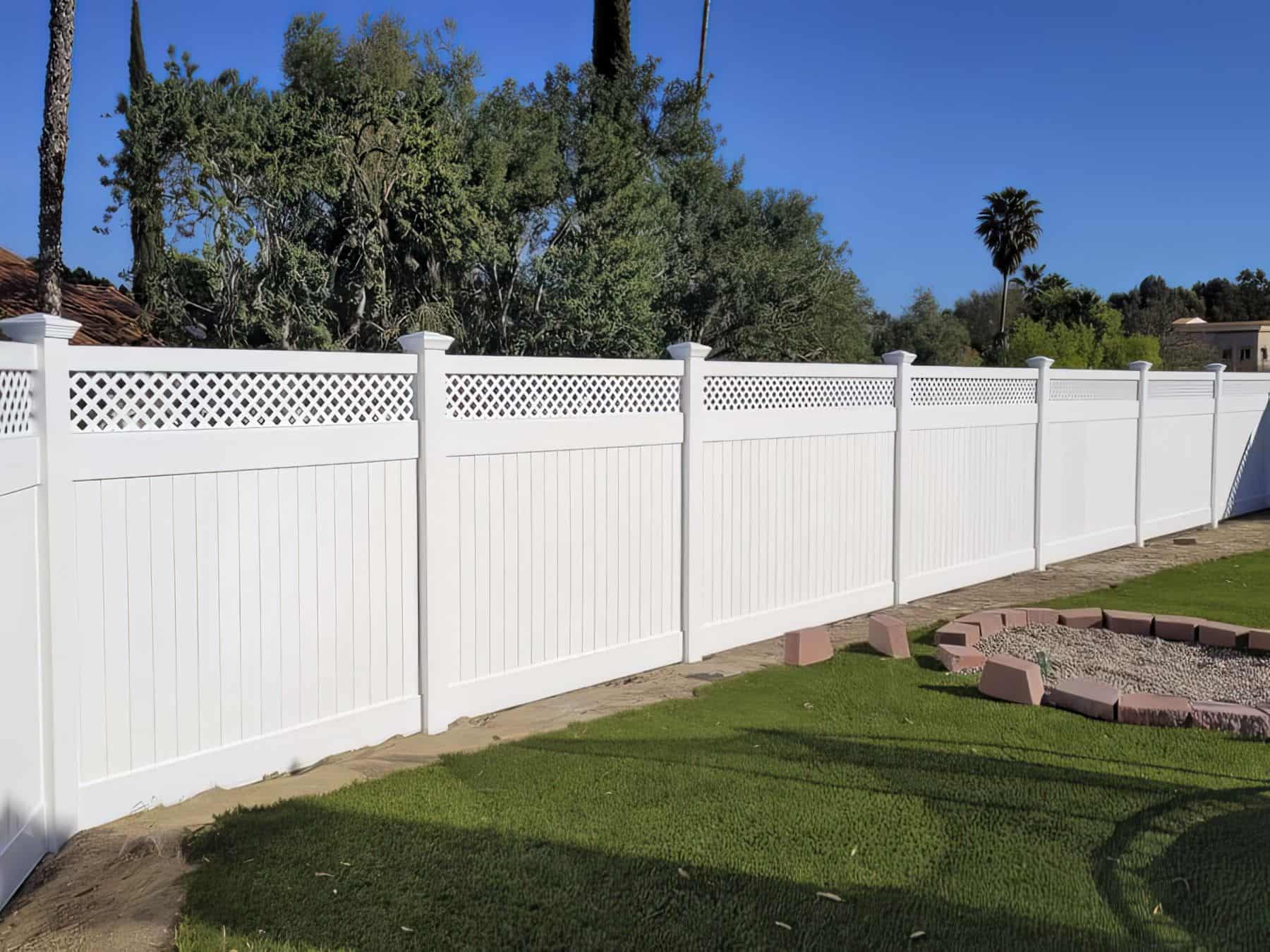 Vinyl pool fence surrounding backyard of suburban home with granite floors, grassy lawn, palm trees, and comfortable couches