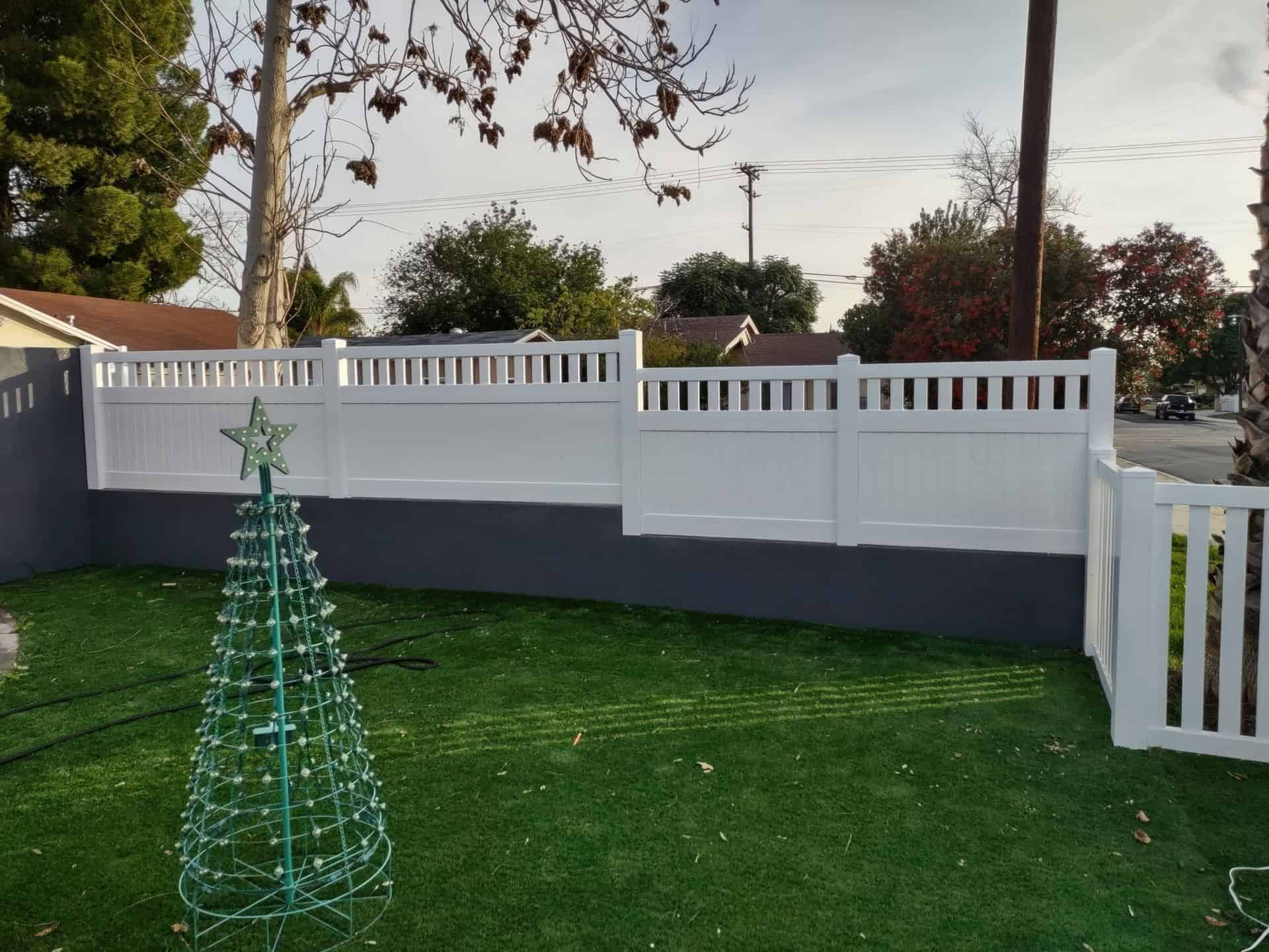Vinyl privacy and picket fence on the ground and other elevated platforms creating boundary around surrounding lawn