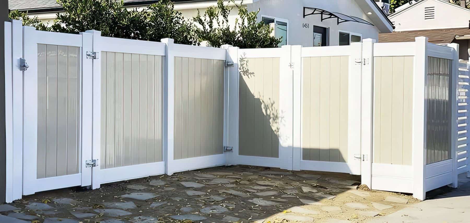 Vinyl privacy two-tone fence with multiple gates leading into modern suburban house from a well designed stone walkway.