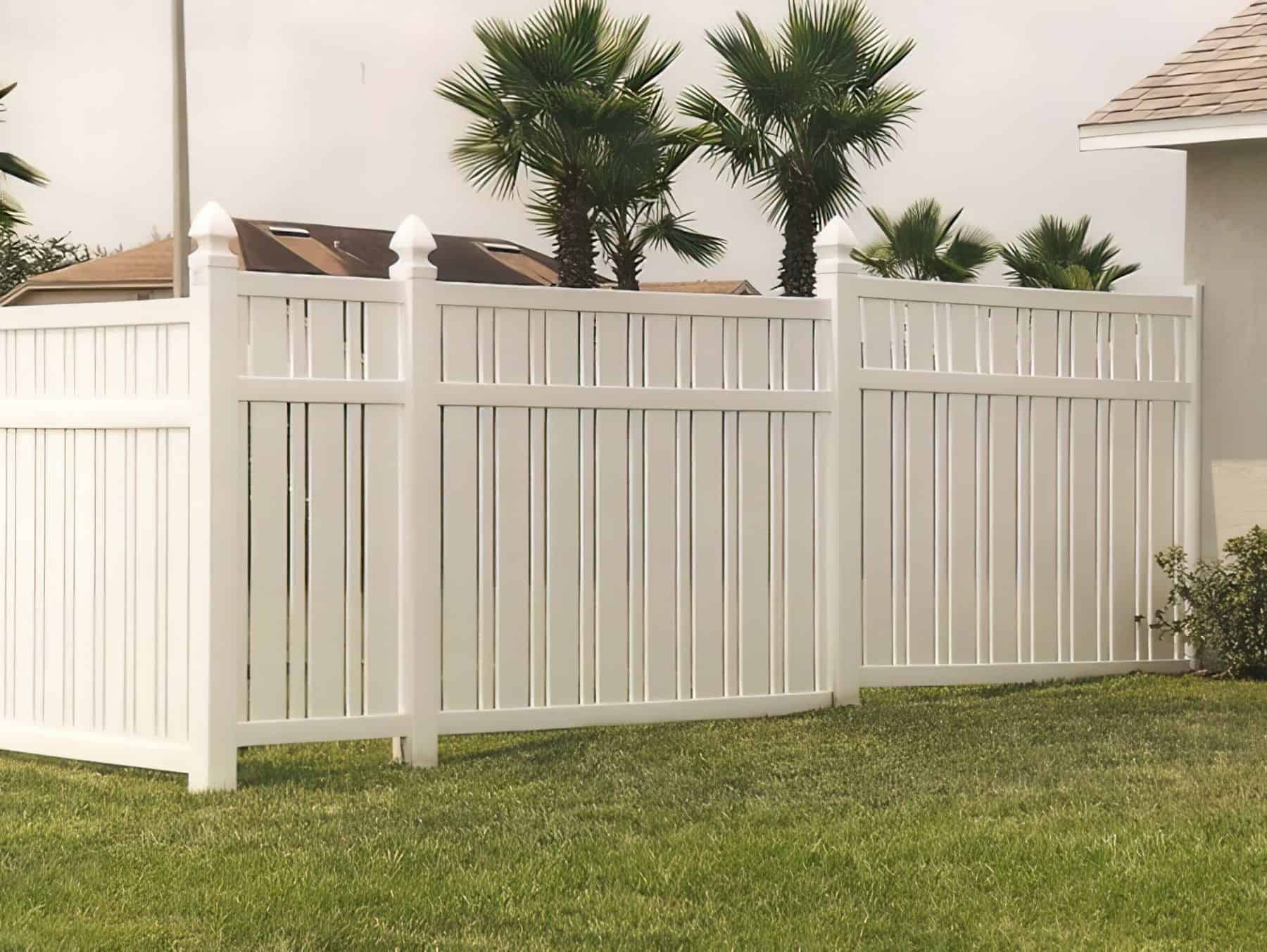 Slatted vinyl semi-privacy fence with stylized gaps in between, beside the muted beige wall and on top of the grassy lawn