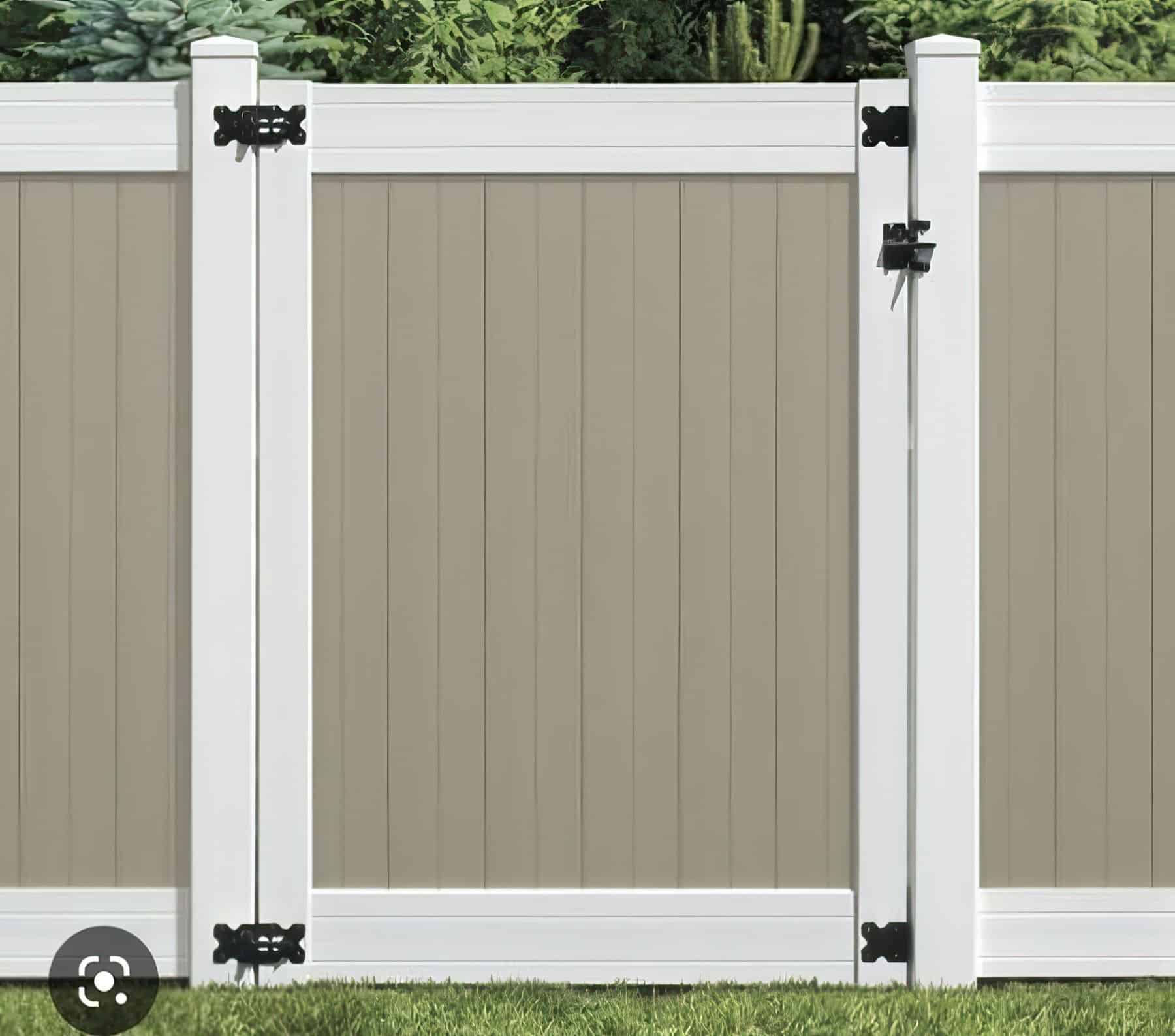 A beige vinyl single side gate featuring a matte white border with contrasting black hinges next to the grassy backyard.